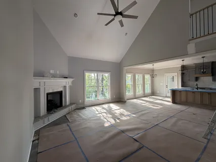 a view of an empty room with a fireplace and a window