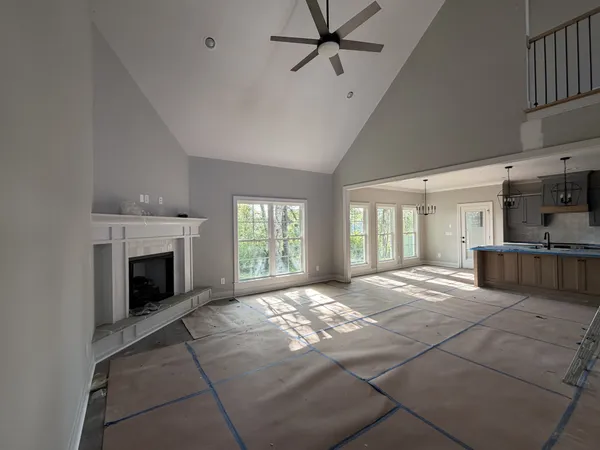 a view of an empty room with a fireplace and a window