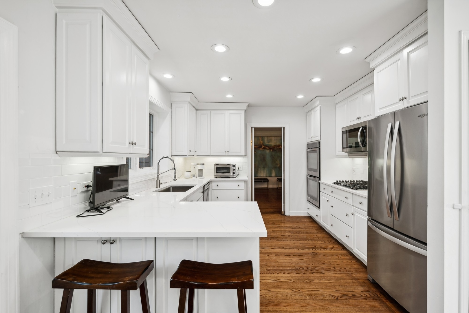 269 Locust Road Winnetka, IL 60093 - Photo 6 of 26 a kitchen with stainless steel appliances a dining table chairs refrigerator and cabinets
