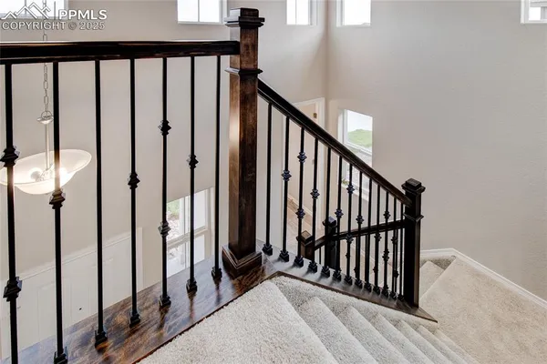 a view of a hallway with wooden floor and staircase