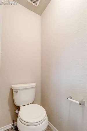 a white toilet sitting next to a white wall