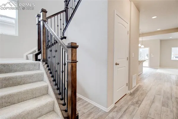 a view of a hallway with wooden floor and staircase