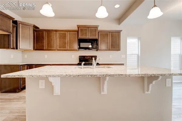 a kitchen with stainless steel appliances granite countertop a sink a stove and a refrigerator