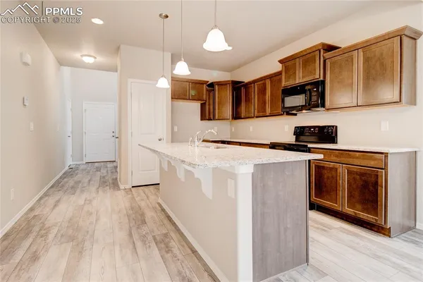 a kitchen with stainless steel appliances granite countertop a stove a sink and a refrigerator