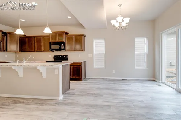 a view of a kitchen with kitchen island a counter top space appliances and a window