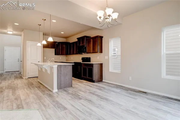 a kitchen with kitchen island granite countertop stainless steel appliances cabinets a window and a sink