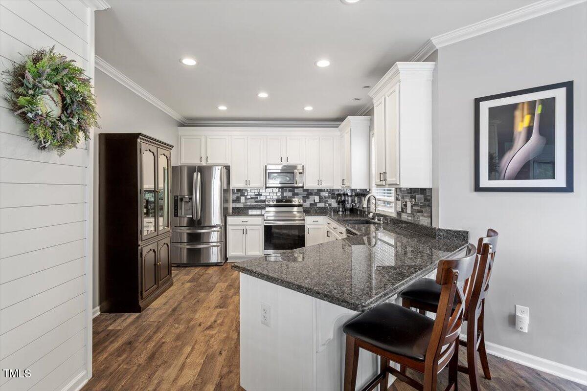 308 Mickleson Ridge Drive Raleigh, NC 27603 - Photo 15 of 51 a kitchen with refrigerator a stove and chairs