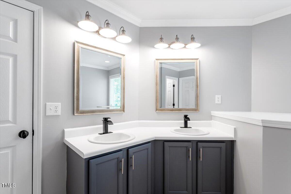 308 Mickleson Ridge Drive Raleigh, NC 27603 - Photo 30 of 51 a bathroom with double vanity sinks a vanity a lamp and a mirror
