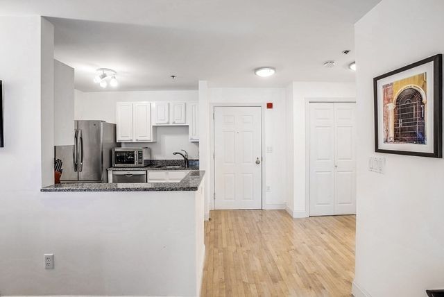 a kitchen with granite countertop a refrigerator sink and cabinets