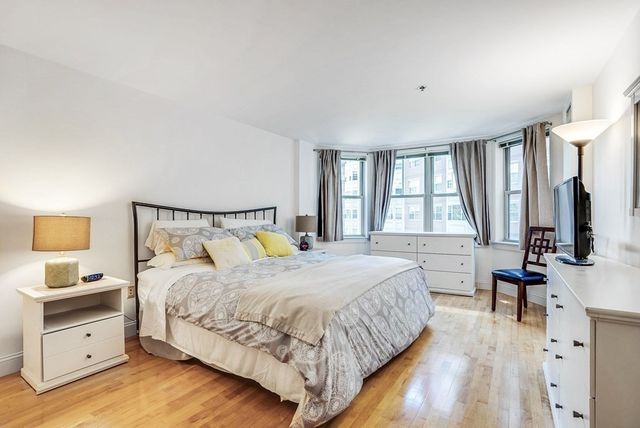 a bedroom with a bed and a large window