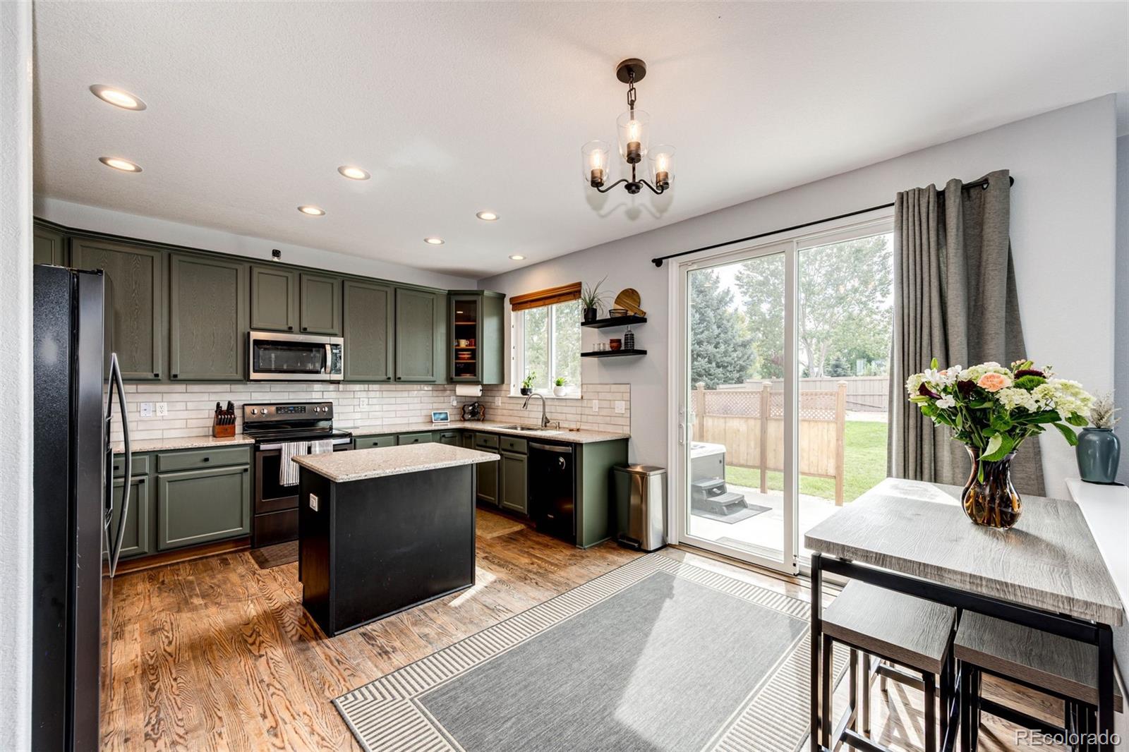 645 Springvale Road Castle Rock, CO 80104 - Photo 11 of 41 a kitchen with a table chairs stainless steel appliances and cabinets