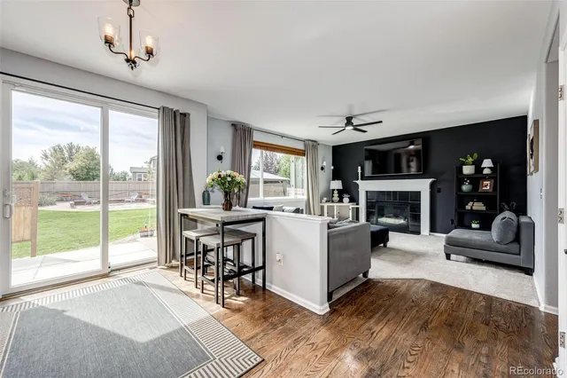 a living room with furniture a fireplace and a large window
