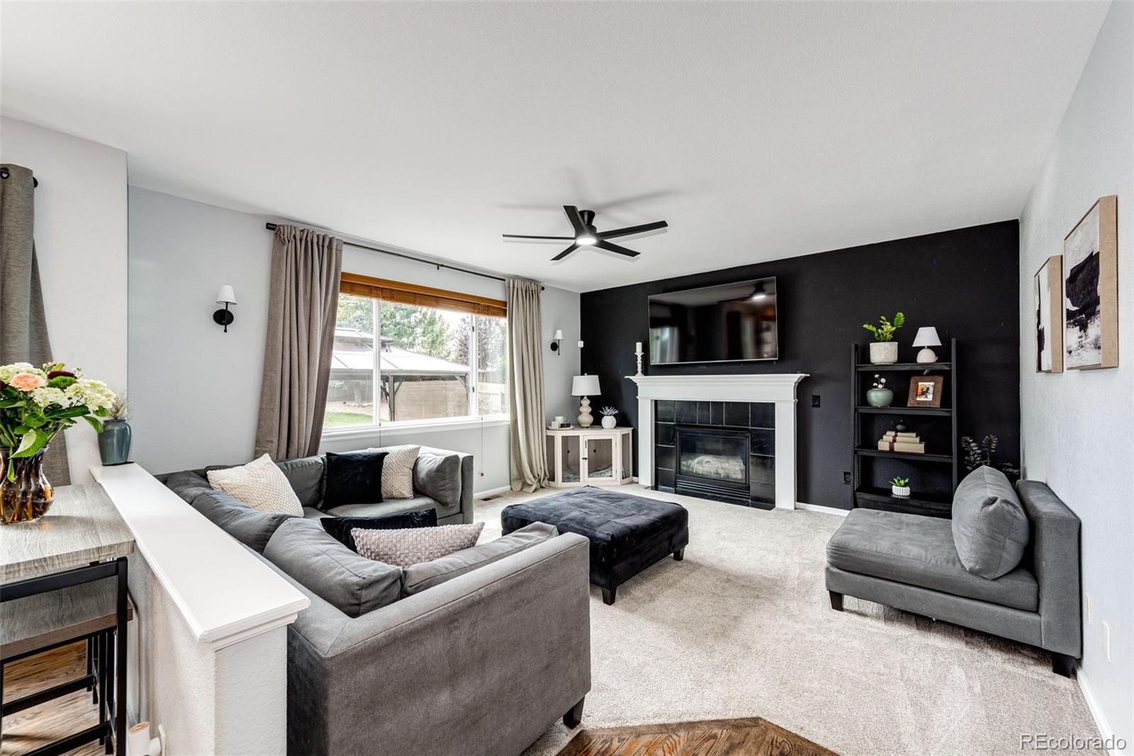 645 Springvale Road Castle Rock, CO 80104 - Photo 13 of 41 a living room with furniture a fireplace and a large window