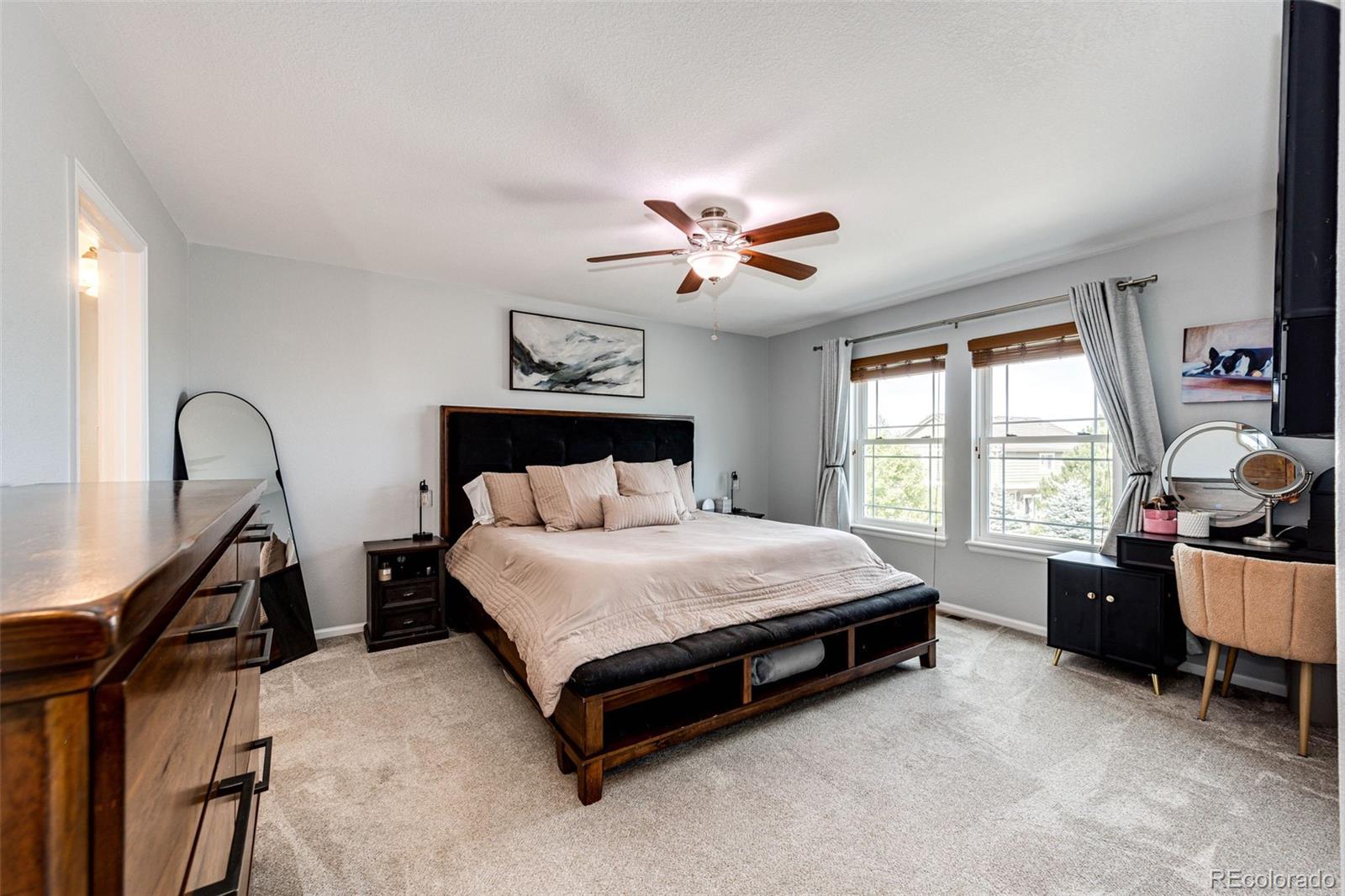 645 Springvale Road Castle Rock, CO 80104 - Photo 18 of 41 a spacious bedroom with a bed and a chandelier