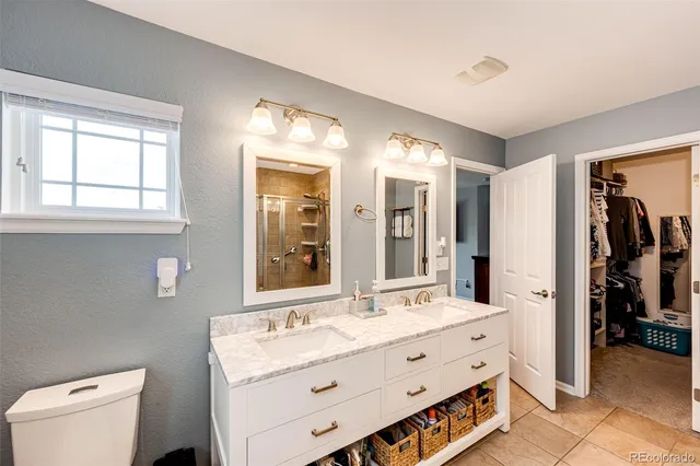 a bathroom with a double vanity sink mirror and toilet