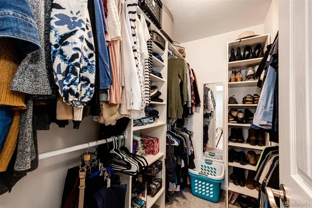 walk in closet with clothes and shoes