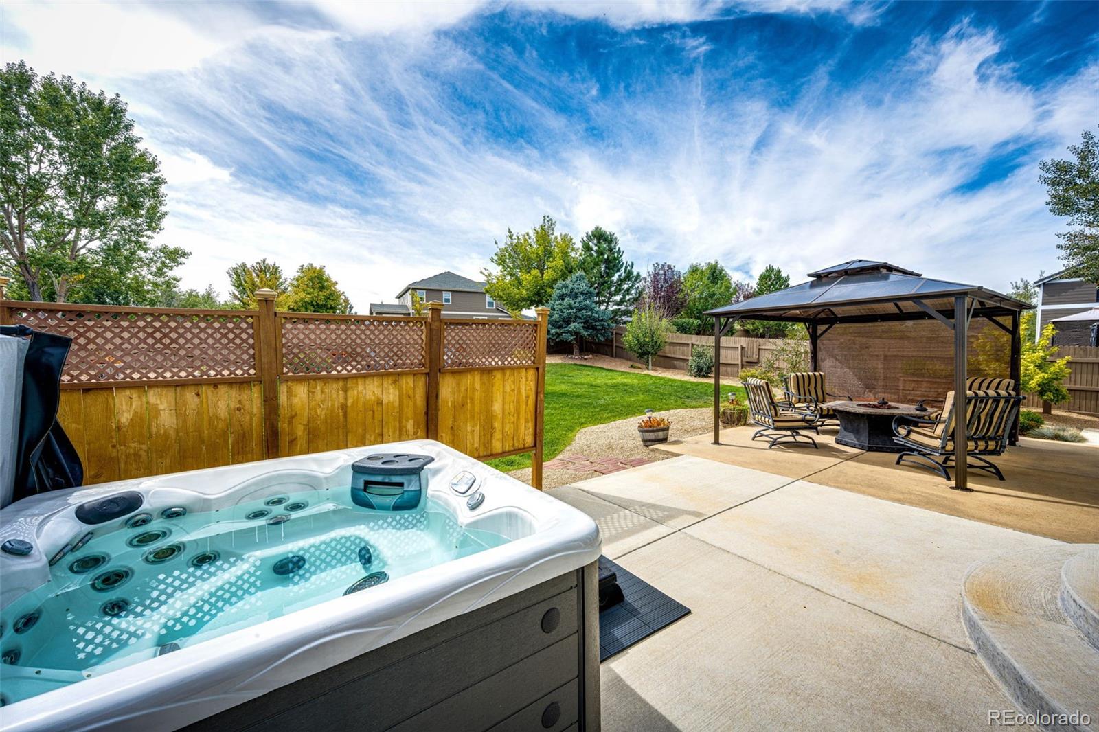 645 Springvale Road Castle Rock, CO 80104 - Photo 31 of 41 a view of backyard with a table and chairs under an umbrella with a small yard