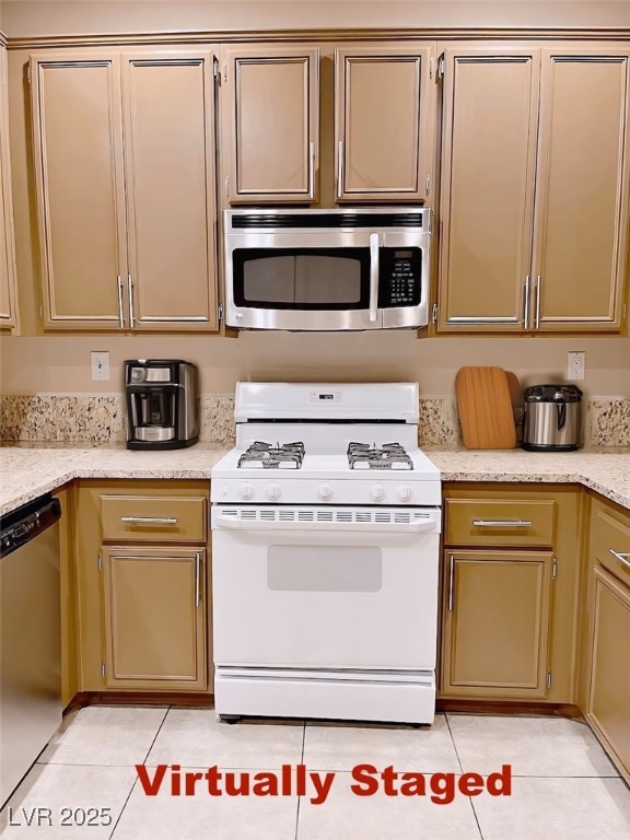 7640 Sierra Paseo Lane Las Vegas, NV 89128 - Photo 5 of 49 Kitchen with appliances with stainless steel finishes, light tile patterned flooring, and light stone countertops