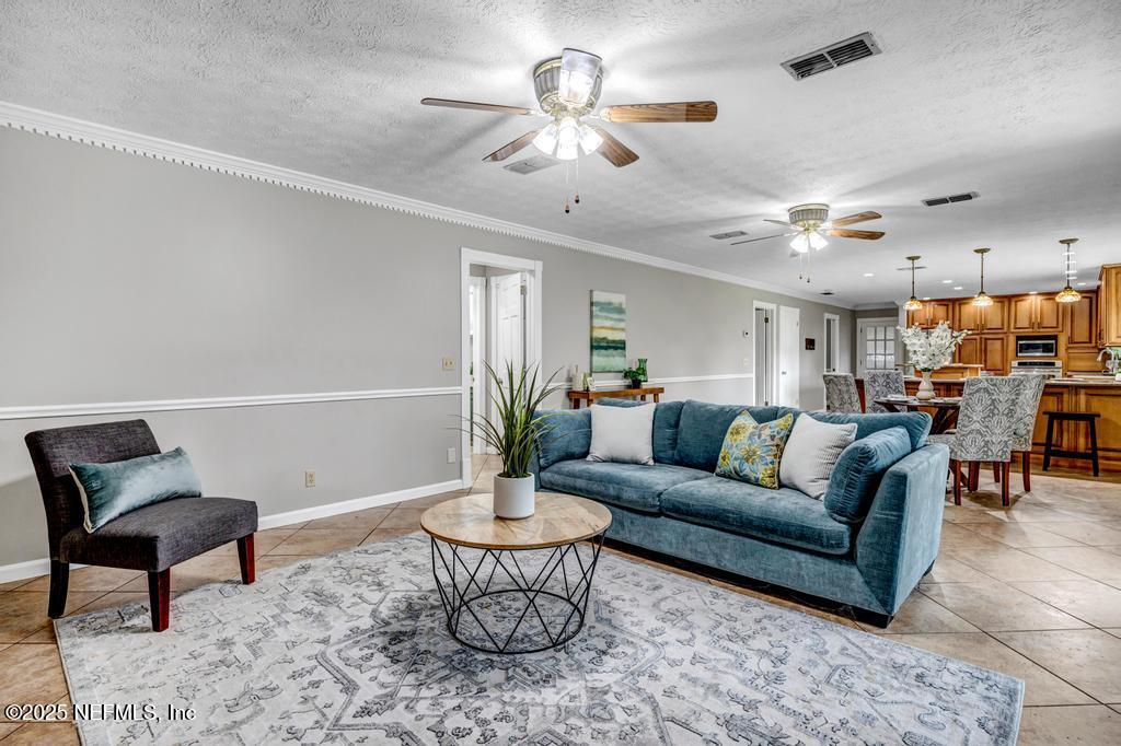 4448 Charter Point Boulevard Jacksonville, FL 32277 - Photo 16 of 47 a living room with furniture and a chandelier