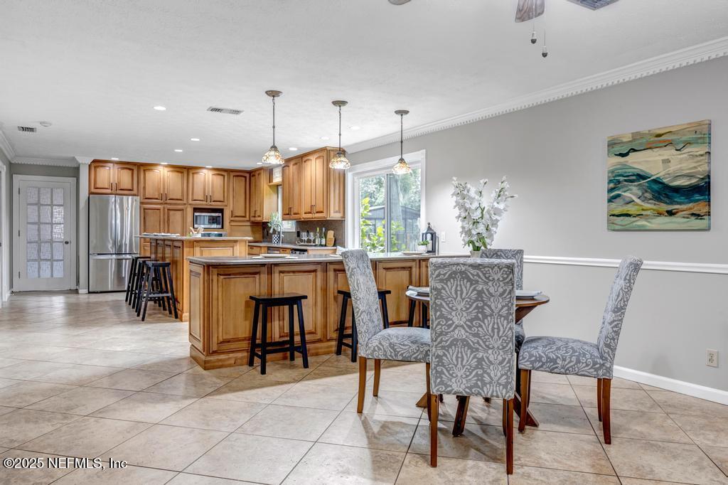 4448 Charter Point Boulevard Jacksonville, FL 32277 - Photo 17 of 47 a kitchen with stainless steel appliances kitchen island granite countertop a table chairs and a refrigerator