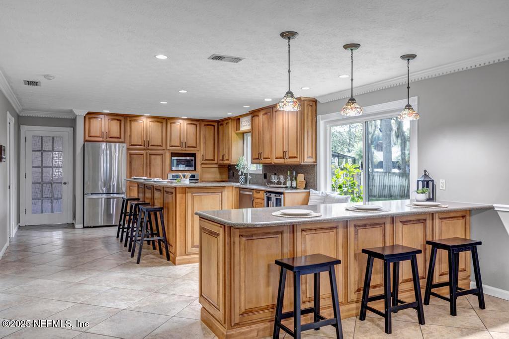 4448 Charter Point Boulevard Jacksonville, FL 32277 - Photo 19 of 47 a kitchen with stainless steel appliances kitchen island granite countertop a table chairs refrigerator and sink