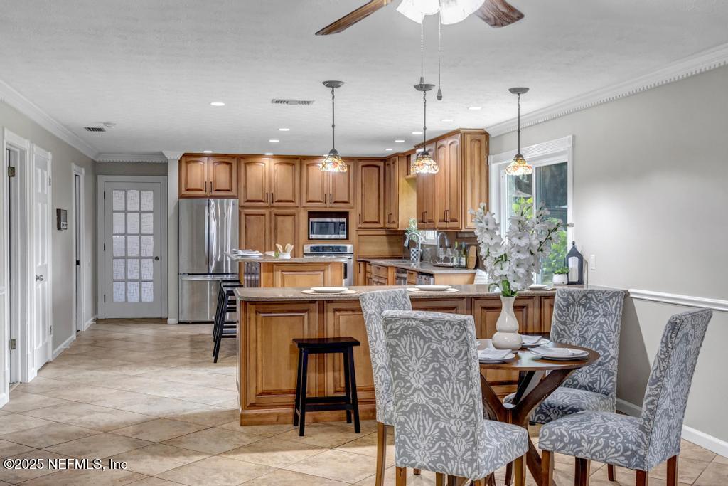 4448 Charter Point Boulevard Jacksonville, FL 32277 - Photo 20 of 47 a kitchen with stainless steel appliances kitchen island granite countertop a dining table chairs and a refrigerator