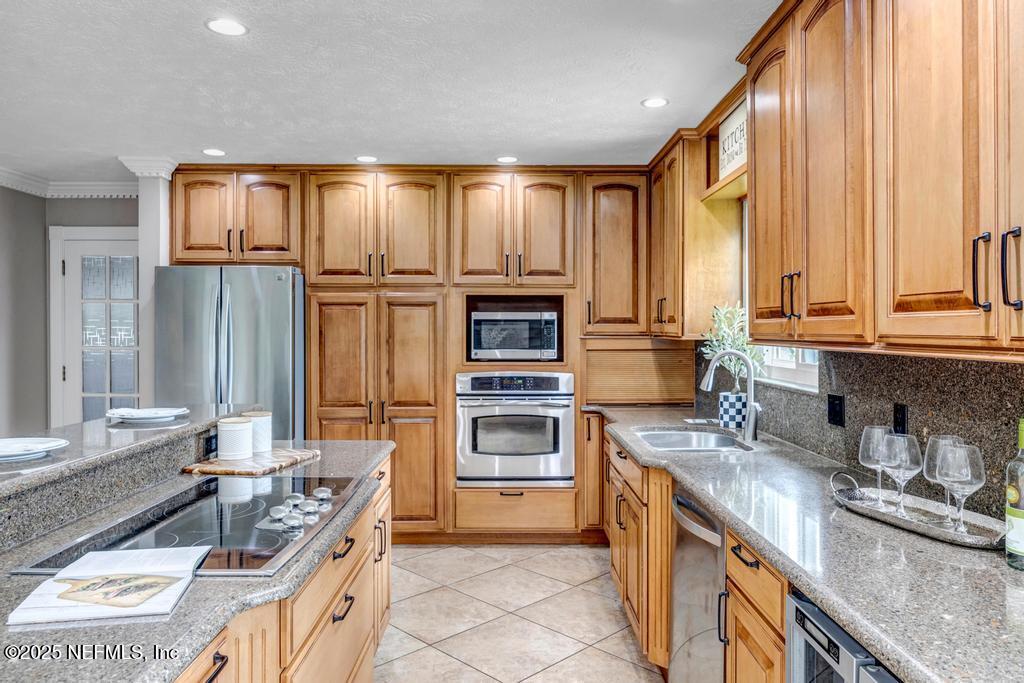 4448 Charter Point Boulevard Jacksonville, FL 32277 - Photo 23 of 47 a kitchen with stainless steel appliances granite countertop a sink and a stove top oven