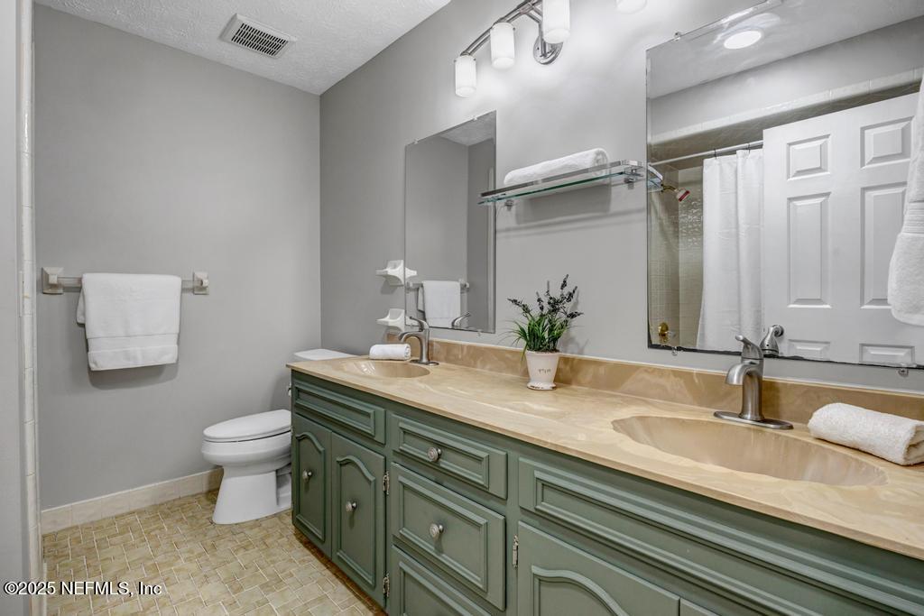 4448 Charter Point Boulevard Jacksonville, FL 32277 - Photo 31 of 47 a bathroom with a granite countertop sink a toilet and a mirror