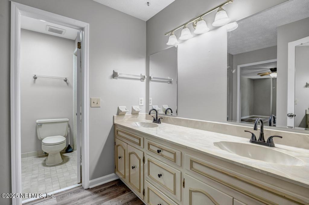 4448 Charter Point Boulevard Jacksonville, FL 32277 - Photo 35 of 47 a bathroom with a granite countertop sink a toilet and a large mirror