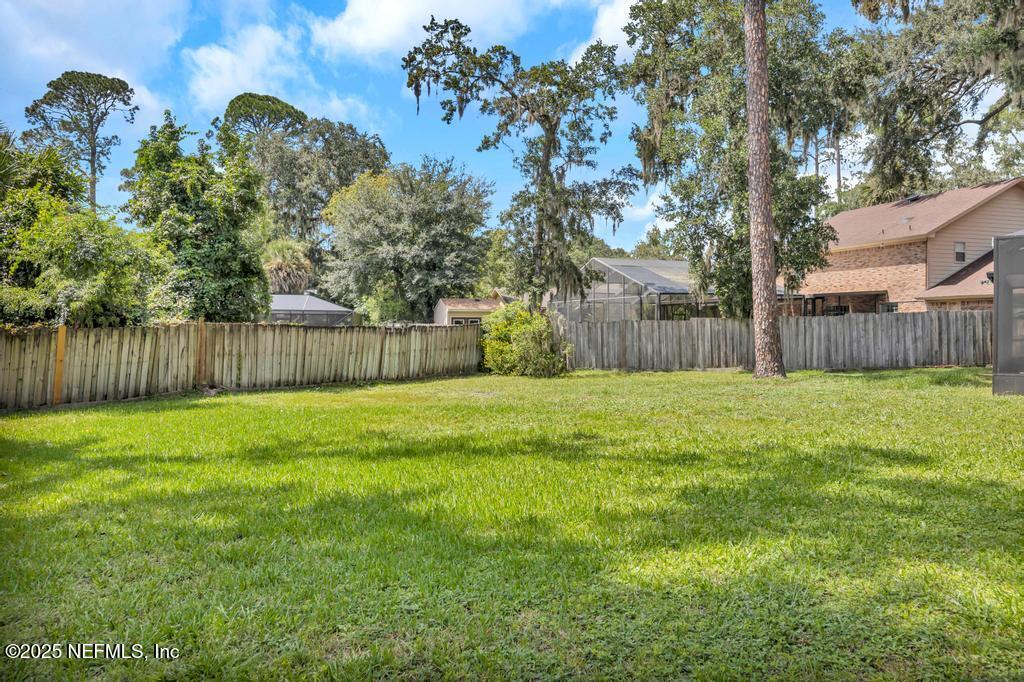4448 Charter Point Boulevard Jacksonville, FL 32277 - Photo 45 of 47 a view of a backyard with large tree and wooden fence