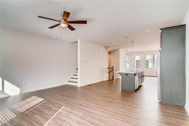 a view of a living room and a ceiling fan with wooden floor