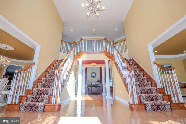 a kitchen with stainless steel appliances granite countertop a refrigerator a sink dishwasher a stove and white countertops with wooden floor