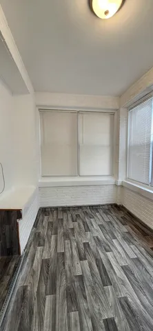 a view of a room with wooden floor and window