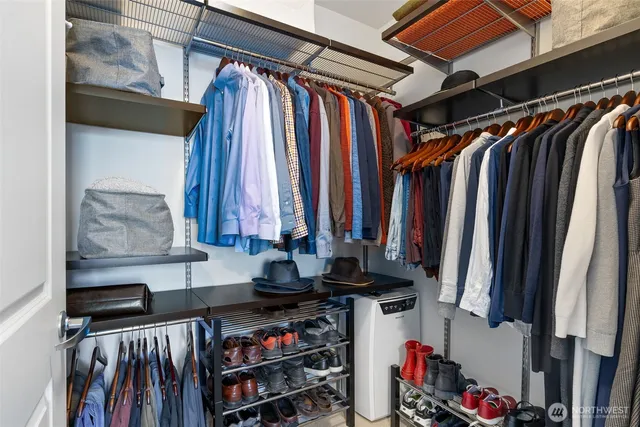 a view of walk in closet with clothes and shoes