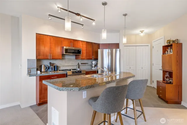 a kitchen with stainless steel appliances granite countertop a sink refrigerator and cabinets