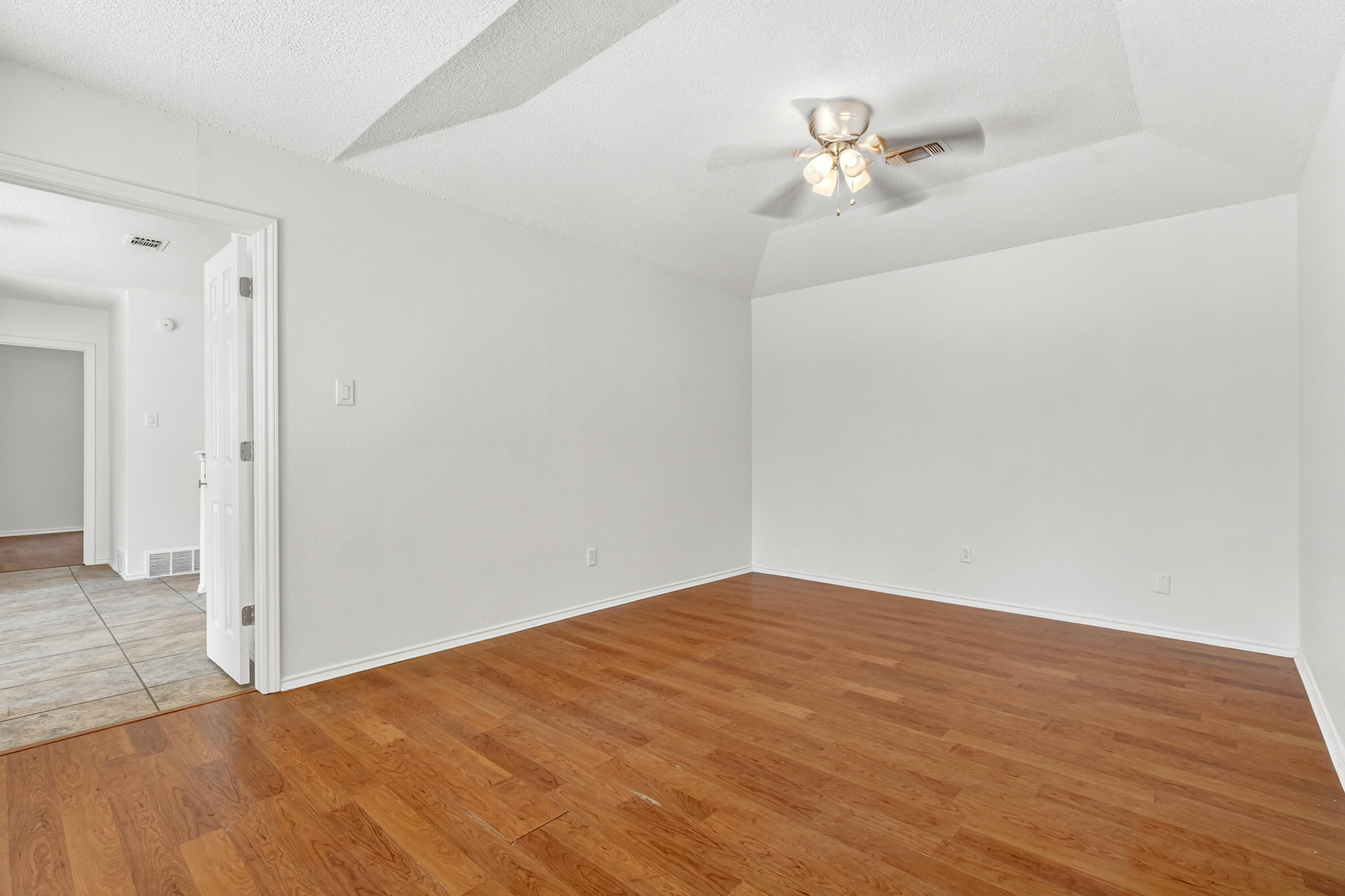 5221 84th Street Lubbock, TX 79424 - Photo 8 of 26 a view of a room with wooden floor and a ceiling fan