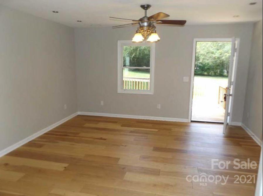 58 Ross Farm Road Waynesville, NC 28786 - Photo 15 of 29 an empty room with wooden floor fan and windows