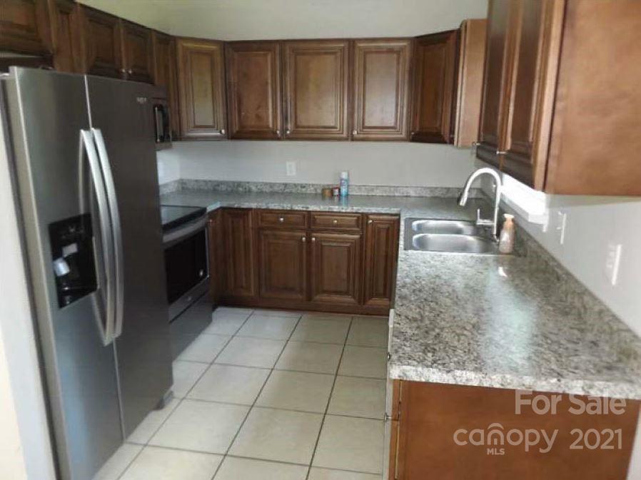 58 Ross Farm Road Waynesville, NC 28786 - Photo 18 of 29 a kitchen with granite countertop a refrigerator and a sink