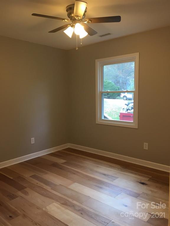 58 Ross Farm Road Waynesville, NC 28786 - Photo 21 of 29 a view of an empty room with wooden floor and a window