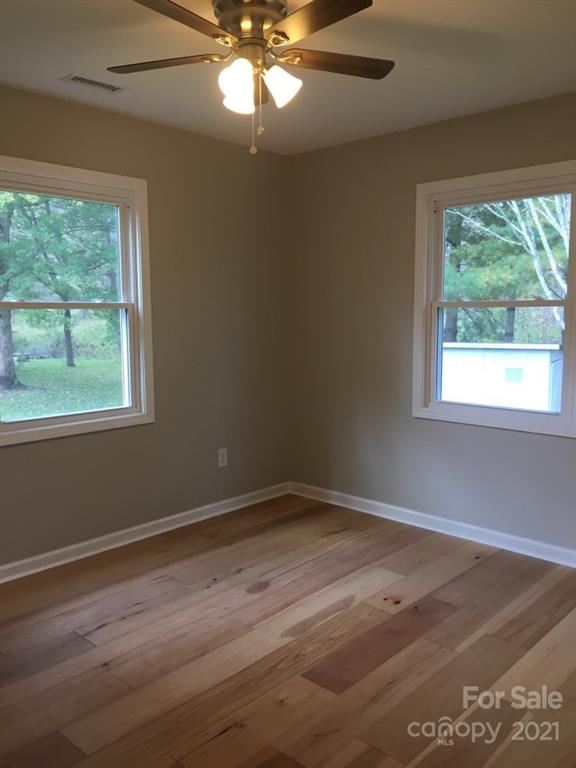 58 Ross Farm Road Waynesville, NC 28786 - Photo 23 of 29 a view of an empty room with wooden floor and a window