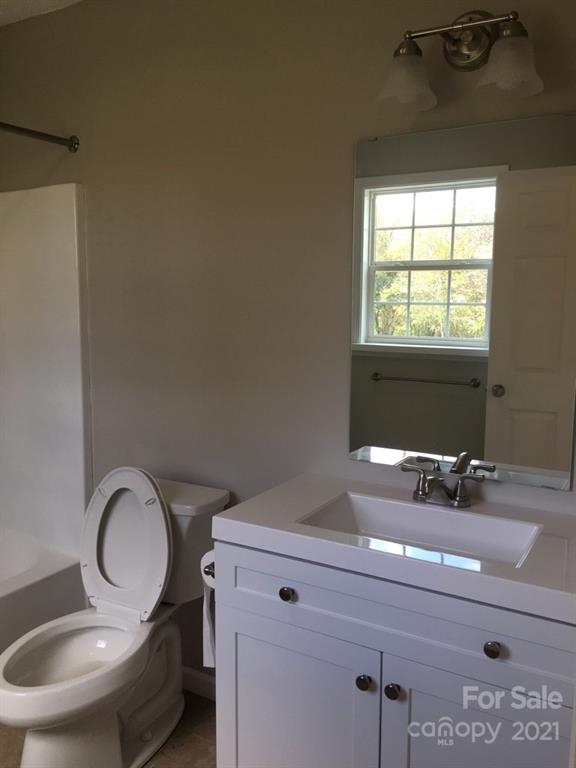 58 Ross Farm Road Waynesville, NC 28786 - Photo 27 of 29 a bathroom with a toilet a sink and mirror