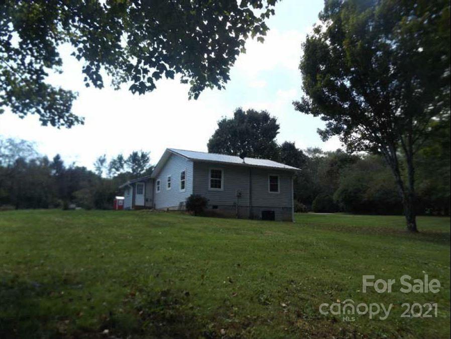 58 Ross Farm Road Waynesville, NC 28786 - Photo 8 of 29 a house that is sitting in the grass with large trees
