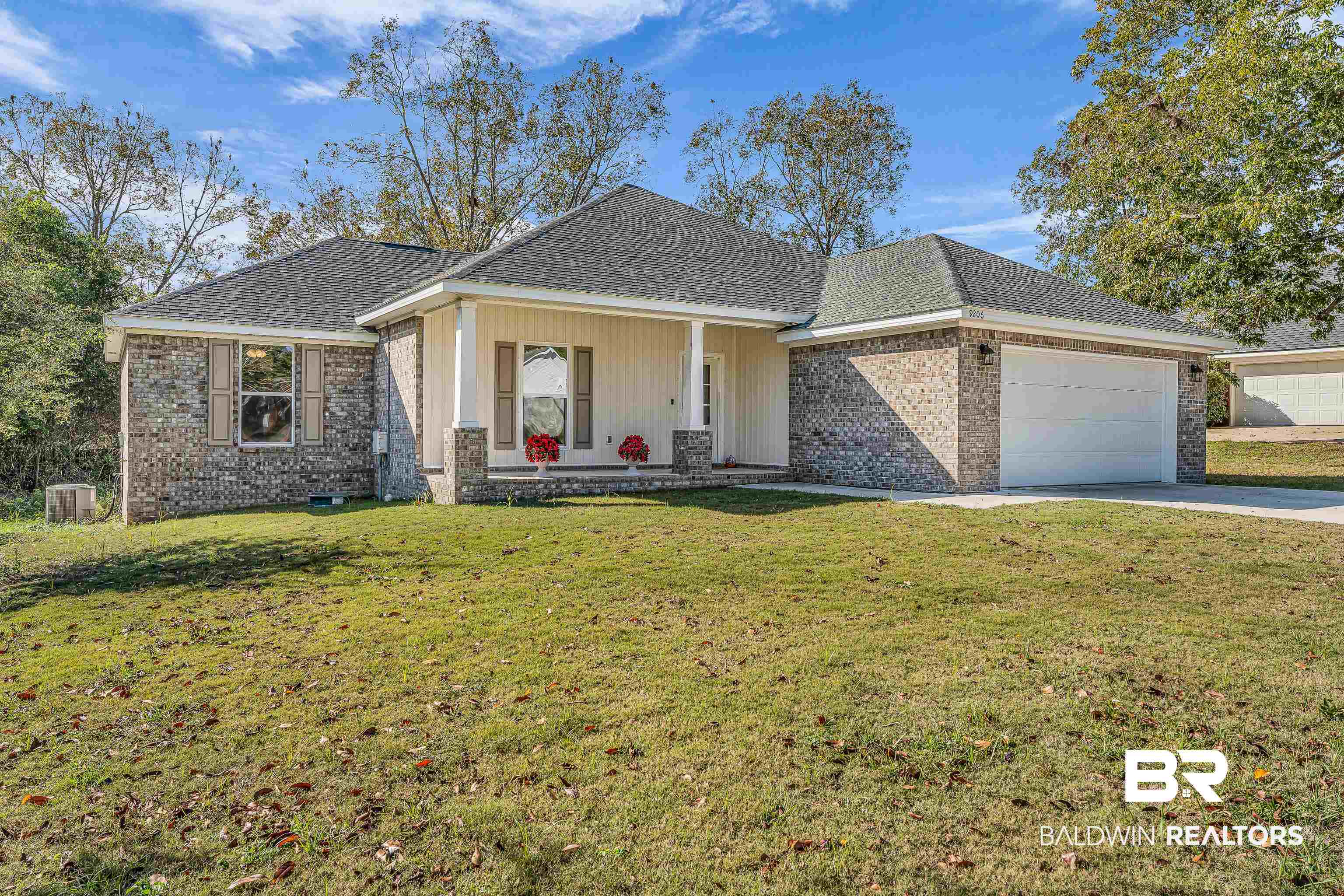 9206 Greenleaf Drive Daphne, AL 36527 - Photo 28 of 32 View of front of home featuring a porch, brick siding, a front yard, roof with shingles, and an attached garage