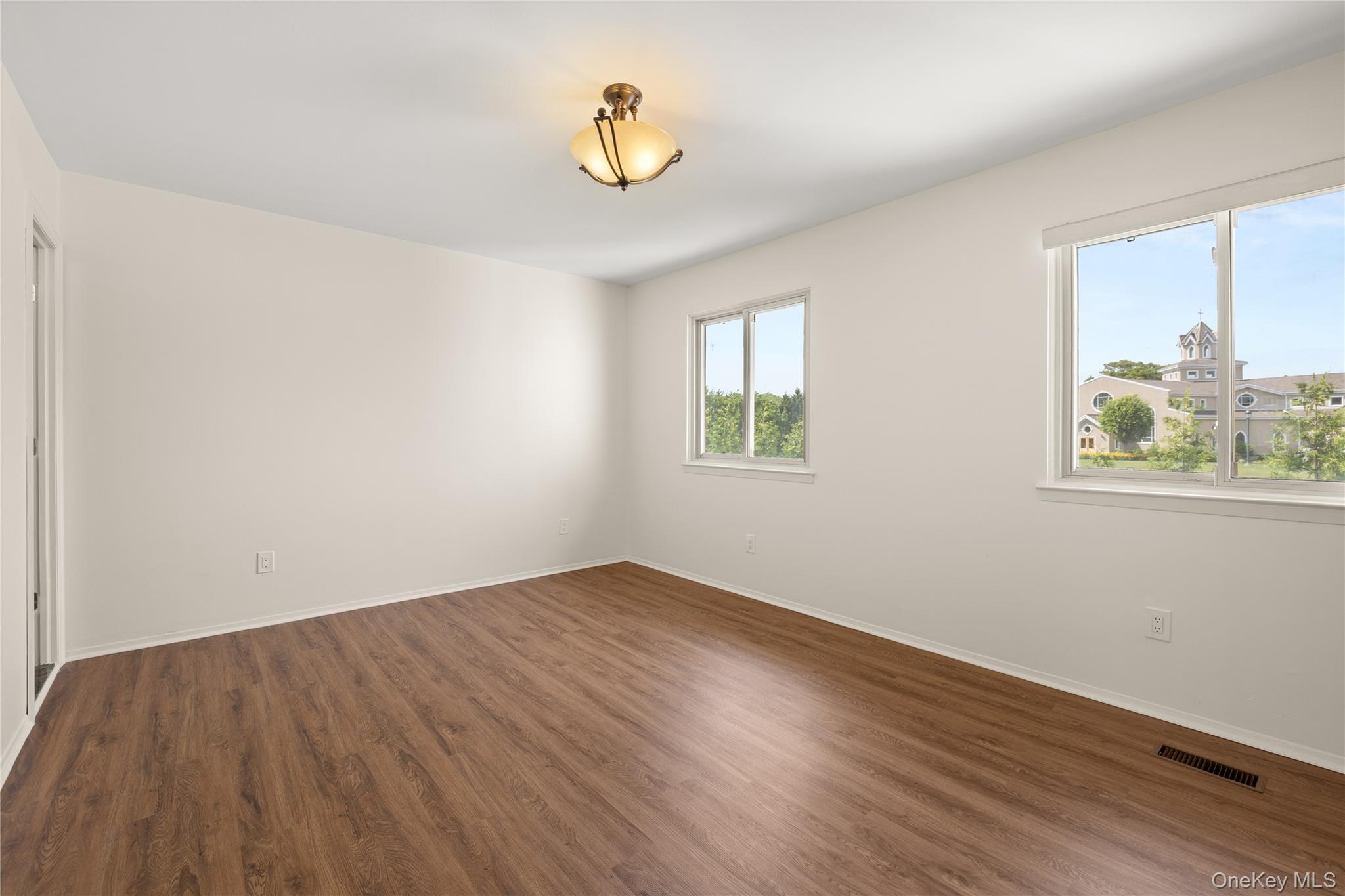 650 Newbridge Road, Unit 15 East Meadow, NY 11554 - Photo 12 of 20 wooden floor in an empty room with a window