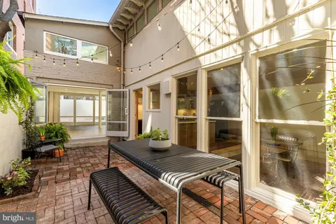 a view of a patio with couches table and chairs and potted plants