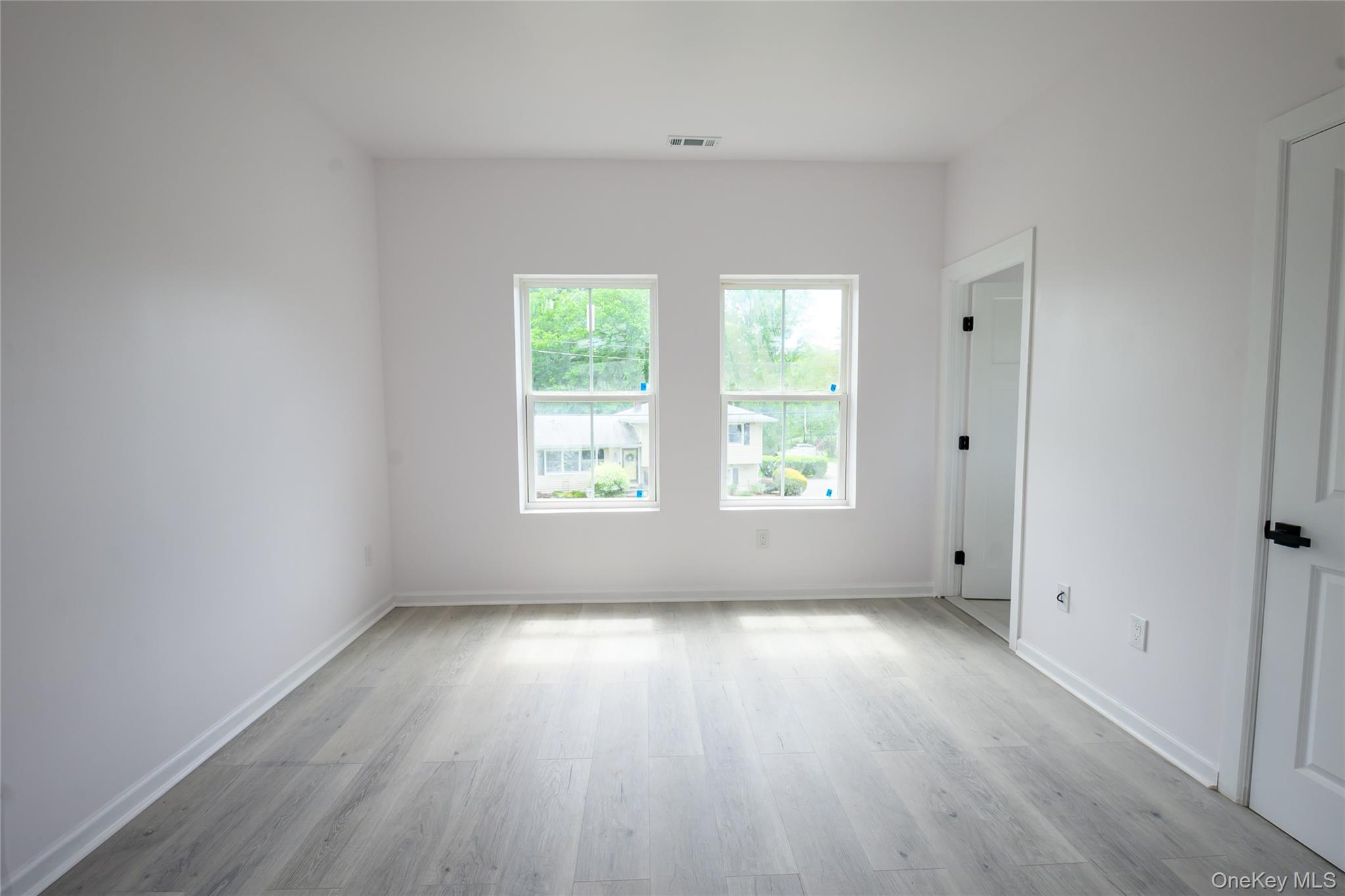 81 Silver Lake Sctn Road Middletown, NY 10940 - Photo 20 of 37 an empty room with wooden floor and windows