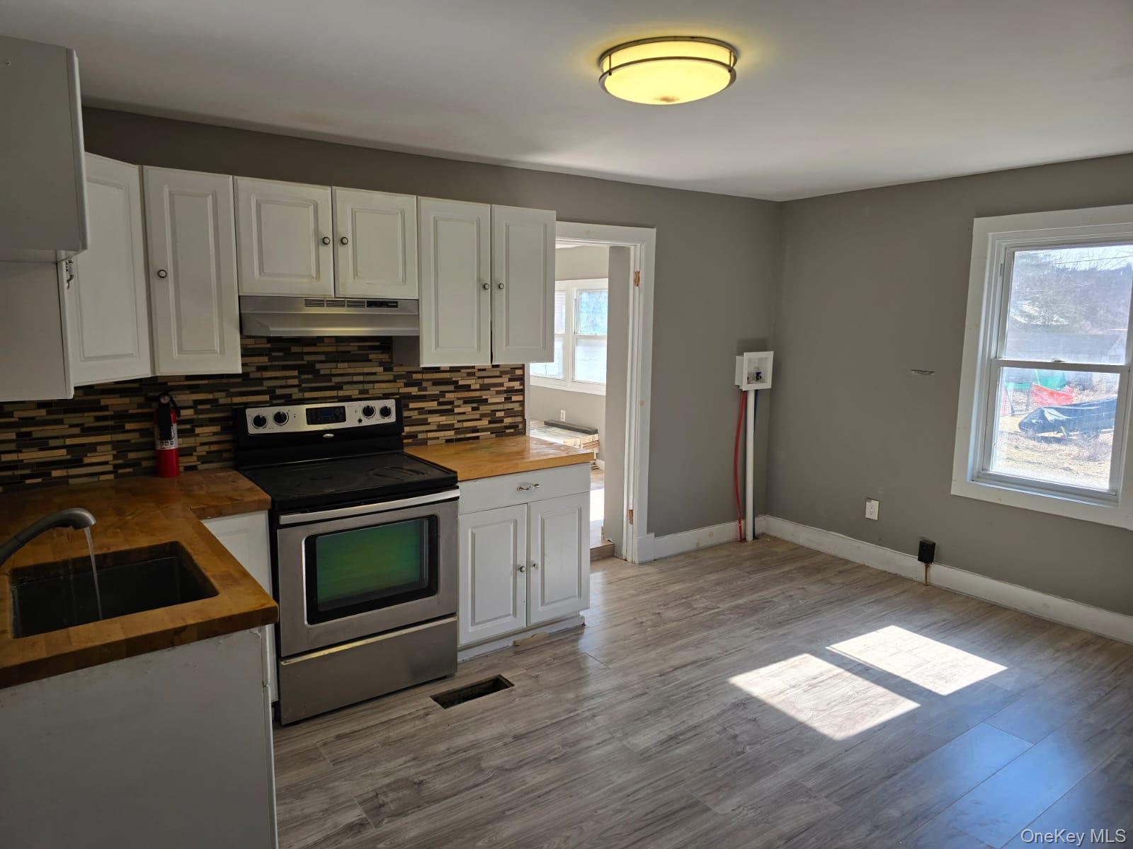 31 Cold Spring Road Monticello, NY 12701 - Photo 4 of 11 a kitchen with granite countertop a stove a sink and a microwave