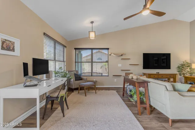 a work room with furniture a flat screen tv and a fireplace