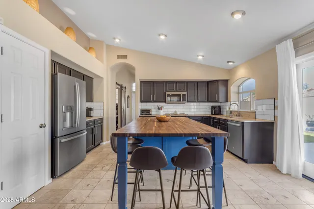 a kitchen with stainless steel appliances kitchen island granite countertop a sink and cabinets