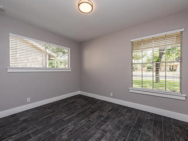 a view of a room with wooden floor and windows
